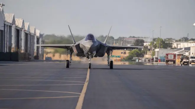Bir f35 uçağı hangardan çıkmış runway'de görünüyor.