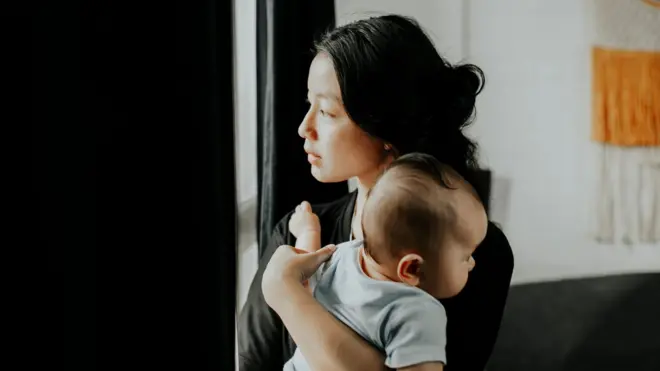 一名女性抱著嬰兒。