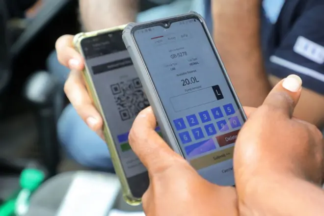 A fuel station employee double checks the fuel QR Code of a vehicle owner within the premises in Colombo, Sri Lanka, 02 August 2022.