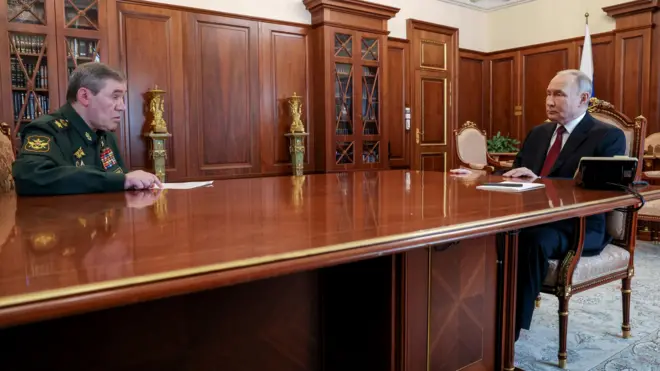 Путин и Герасимов сидят за столом на значительном расстоянии друг от друга (но не на разных концах стола).