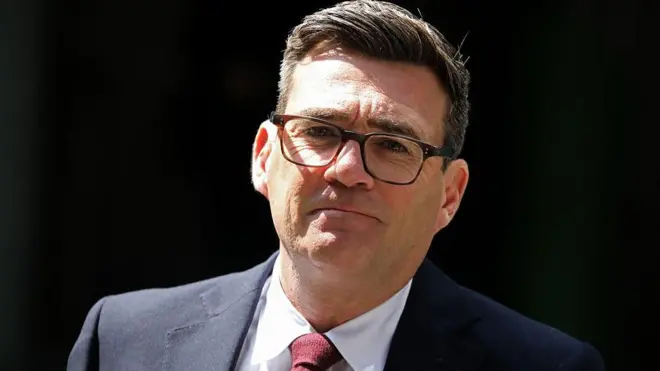 Andy Burnham, nuevo primer ministro de Reino Unido. Tiene el pelo castaño corto, con anteojos, una chaqueta oscura y corbata roja