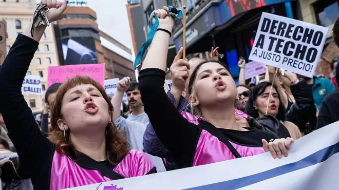 Manifestantes gritan y muestran un cartel con el mensaje "derecho a techo a un justo precio" en una protesta contra el coste de la vivienda en Madrid. 