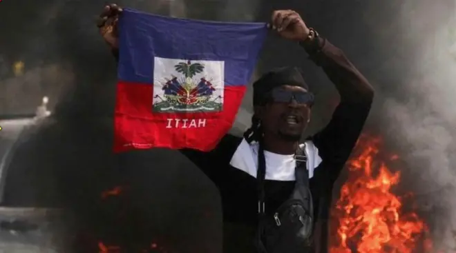 A demonstrator holds up a Haitian flag during a protest against Prime Minister Ariel Henry's government and insecurity, in Port-au-Prince, Haiti on 1 March 2024