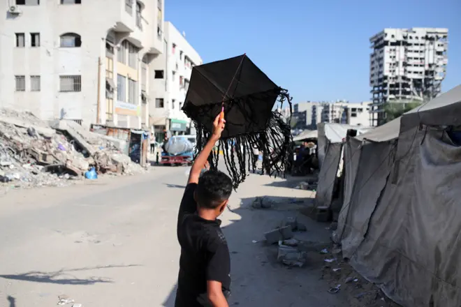 صبي يحاول أن يُطير طائرة ورقية في مخيم للنازحين في مدينة غزة في 23 أغسطس/آب 2026.
