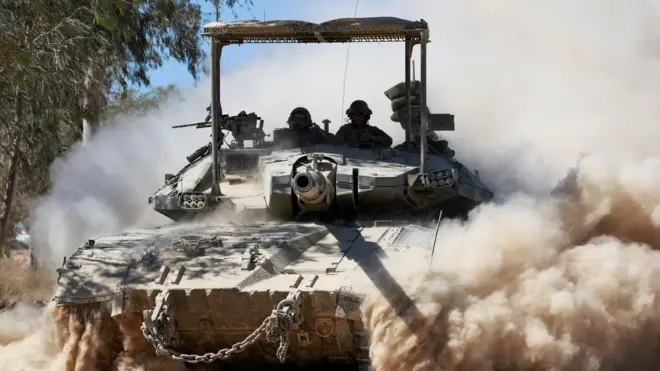 دبابة يظهر على متنها جنود إسرائيليون وتثير غباراً حولها