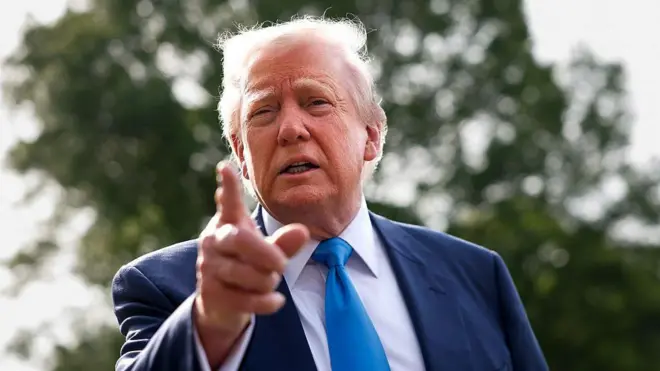 Трамп показывает рукой в объектив снимающей его камеры