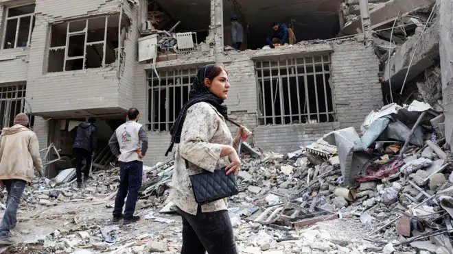 A women walks through rubble in Tehran, Iran 