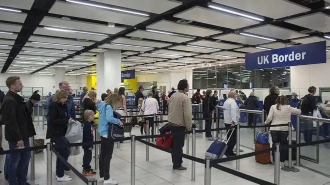 ব্রিটেনের একটি বিমানবন্দরে ইমিগ্রেশনের জন্য অপেক্ষমান যাত্রী।