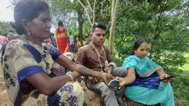 బయోమెట్రిక్ వేలిముద్ర వేస్తున్న గిరిజన మహిళ