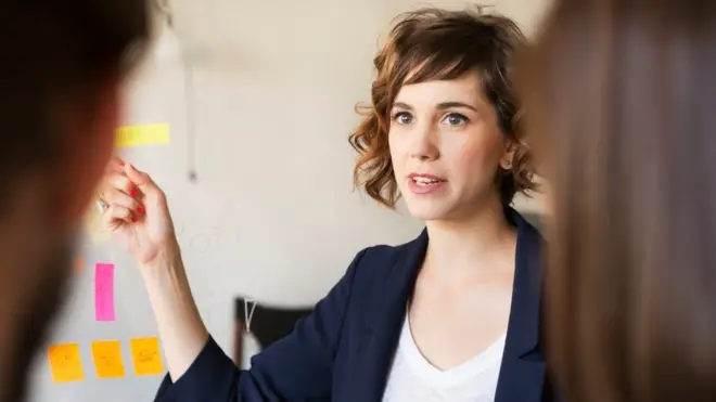 امرأة تقود آخرين في مكتب العمل