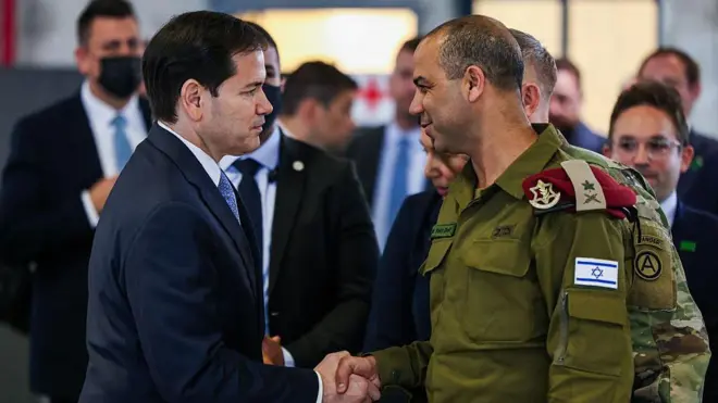 ABD Dışişleri Bakanı Marco Rubio,İsrailli Tuğgeneral ile gülerek el sıkışıyor.