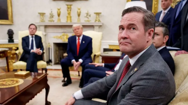 Mike Waltz pictured looking into the camera in the foreground during a meeting in the Oval Office - Mark Rutte is visible sitting next to Donald Trump, with Pete Hegseth also visible next to Waltz