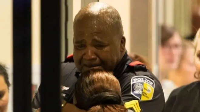 Un policía de la unidad de tránsito llora en la entrada de la emergencia del Hospital Universitario Baylor.