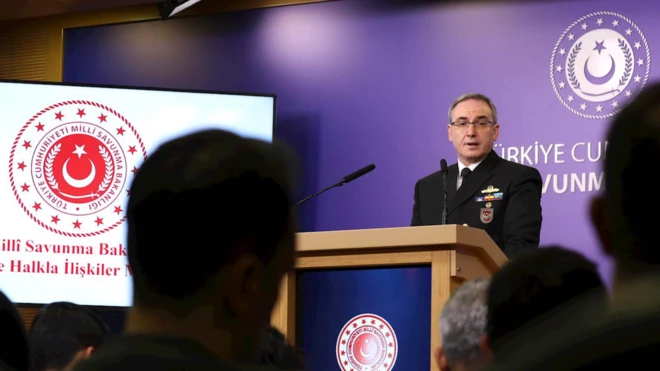 Millî Savunma Bakanlığında haftalık medya bilgilendirme toplantısında bir subay konuşuyor, yanda ekran var. 