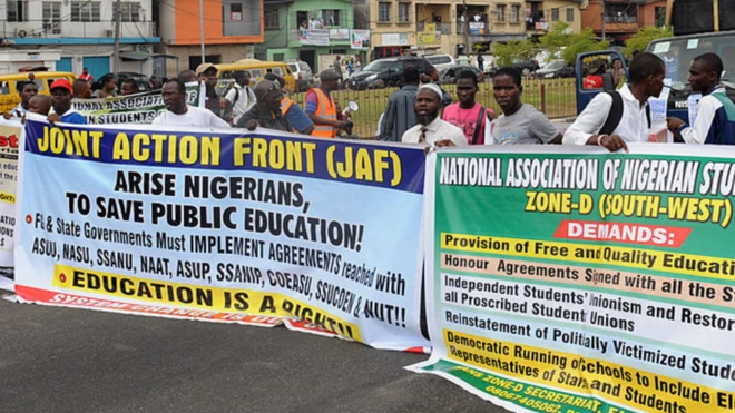 Lecturers and students carry placards dey protest strike for Universitites