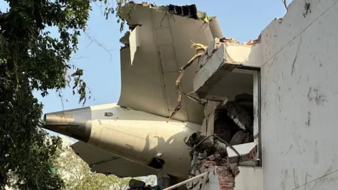 लंडनला जाणाऱ्या विमानाचा अहमदाबादेत अपघात झाला. त्यातील विमानाचा मागचा भाग एका इमारतीवर दिसत आहे. 