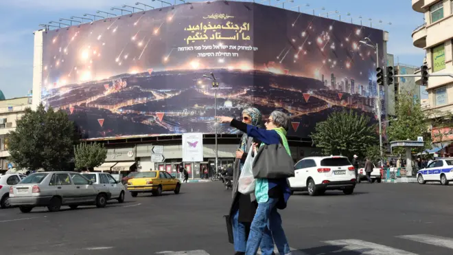 امرأتان تسيران في أحد الشوارع الإيرانية وتبدو الحياة طبيعية 