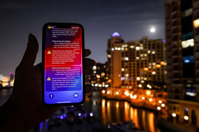 رسائل بالإنجليزية والعربية تظهر على شاشة هاتف محمول أرسلتها وزارة الداخلية الإماراتية، حذرت عبرها سكان دبي وأبو ظبي من هجوم صاروخي إيراني مُحتمل قبيل اعتراض صاروخ في دبي في 5 مارس/آذار 2026
