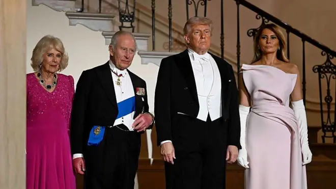 Урочиста сцена в розкішній залі з високими стелями та колонами. Король і королева, Дональд і Меланія Трамп у формальному вечірньому вбранні стоять у ряд. По обидва боки – почесна варта у парадній формі з прапорами та церемоніальними гвинтівками. Глянцева підлога віддзеркалює фігури й світло.