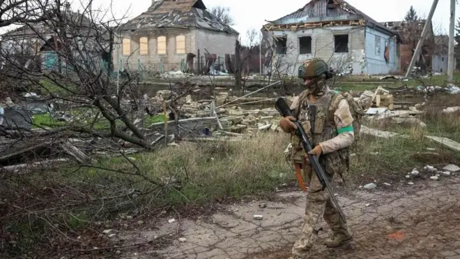 A Ukrainian soldier carrying a gun on patrol in Donetsk
