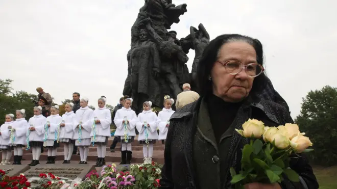 Жінка біля пам'ятника у Бабиному Яру