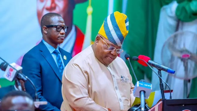 demola Adeleke ati ẹṣọ alaabo rẹ nibi ipade apero kan, gbohungbohun awọn akọroyi wa niwaju rẹ