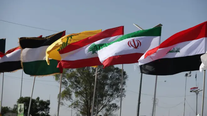 صورة تظهر عدة أعلام بينها علم إيران