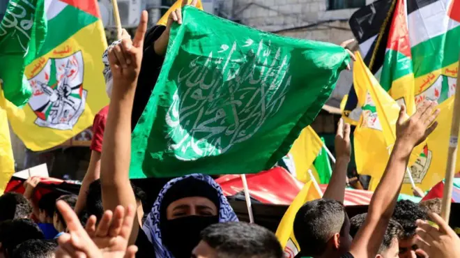 فلسطينيون يلوحون بالأعلام الفلسطينية وأعلام حركتي حماس وفتح خلال مسيرة تضامن مع غزة، في نابلس 26 أكتوبر/ تشرين أول 2023