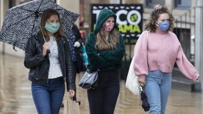 yağmurda yürüyen genç kızlar