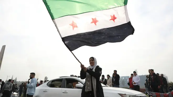 敘利亞女性揮舞代表叛軍的旗幟