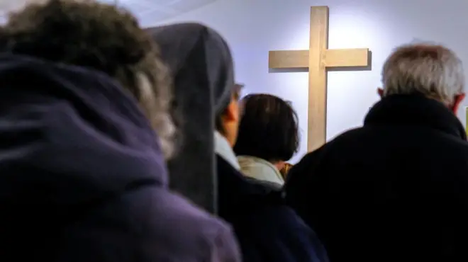 Les fidèles prient devant la croix
