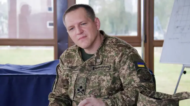 Олександр Півненко у військовій формі сидить у приміщенні на тлі вікна 