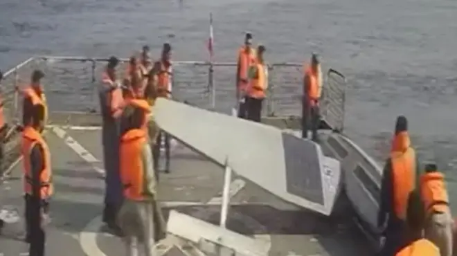 تصاویر تلویزیون ایران نشان می دهد بیش از ۱۲ پرسنل نیروی دریایی ایران در حال هل دادن دو شناور بدون سرنشین آمریکا از عرشه شناور خود به داخل دریا هستند