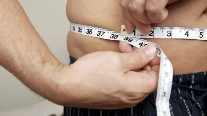 Hombre midiéndose la cintura