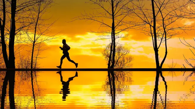 Човек који трчи уз залазак сунца