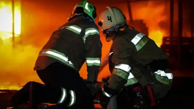 Abariko bagerageza kuzimya imiriro inyuma y'igitero i Kharkiv