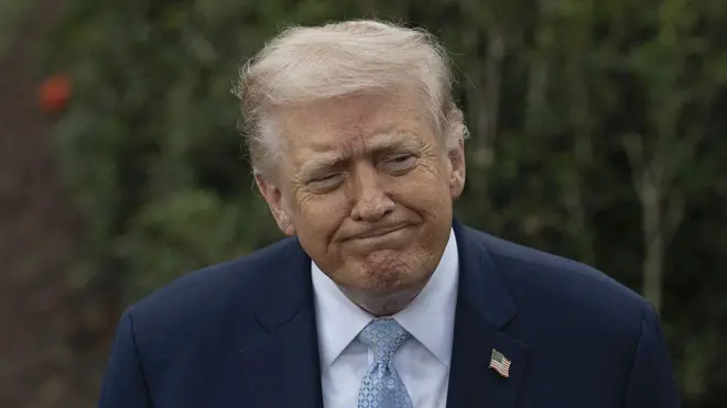 Trump mavi bir kravatla kameralara tebessüm ediyor