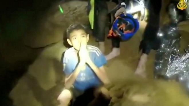 One of the boys trapped in a cave in Thailand greets rescuers