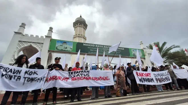 Aksi bendera putih di depan pintu gerbang Masjid Raya Baiturrahman, Banda Aceh, Kamis (18/12).