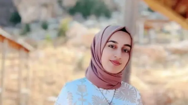 Pembe baş örtülü bir kadın