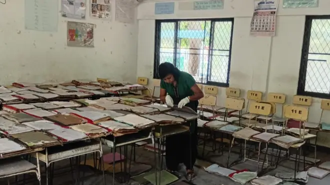 හානිවූ ලේඛන පරීක්ෂාකරන නිලධාරිනියක්