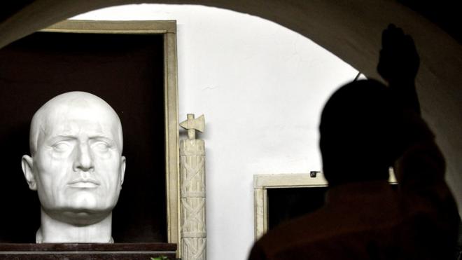 一名游客向墨索里尼的雕像作法西斯主义敬礼。