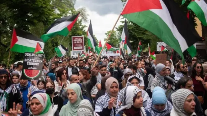 Manifestação pró-Palestina, com dezenasbetsul apppessoas na rua e muitas bandeiras