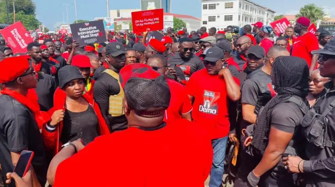 Opposition party supporters clad in red and black protesting executive intimidation and harassment