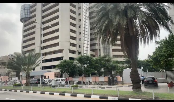 Aworan ile nla to rẹwa pẹlu awọn ọkọ ati awọn eeyan nitosi rẹ