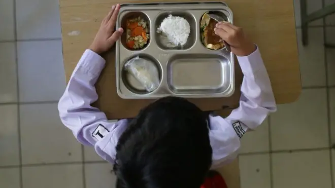 Seorang siswa di Bogor, Jawa Barat, menyantap makan bergizi gratis pada hari pertama program ini diluncurkan, awal Januari 2025.