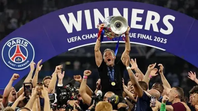 Luis Enrique dey for di back of one of im staff as e hold di European Cup for air