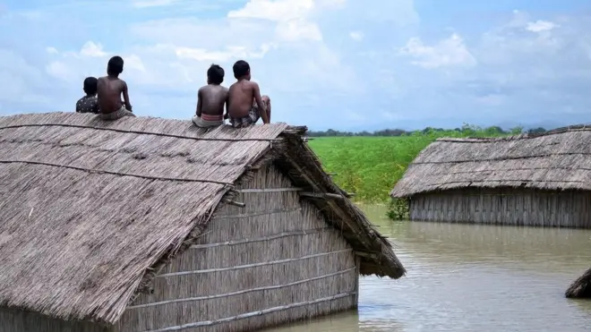 أطفال لاذوا بسطح كوخ غارق جراء فيضان البراهمابوترا عام 2016 بجنوب كَمرب بالهند