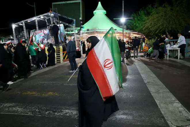 Mwanamke akiwa amebeba bendera ya Iran