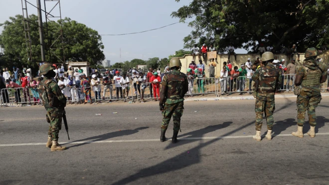 Soldiers fully armed at a voting center where supporters are observing sorting and counting